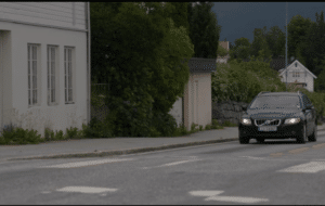 Fotografi en bil som kommer kjørende mot deg i et tettbygd strøk