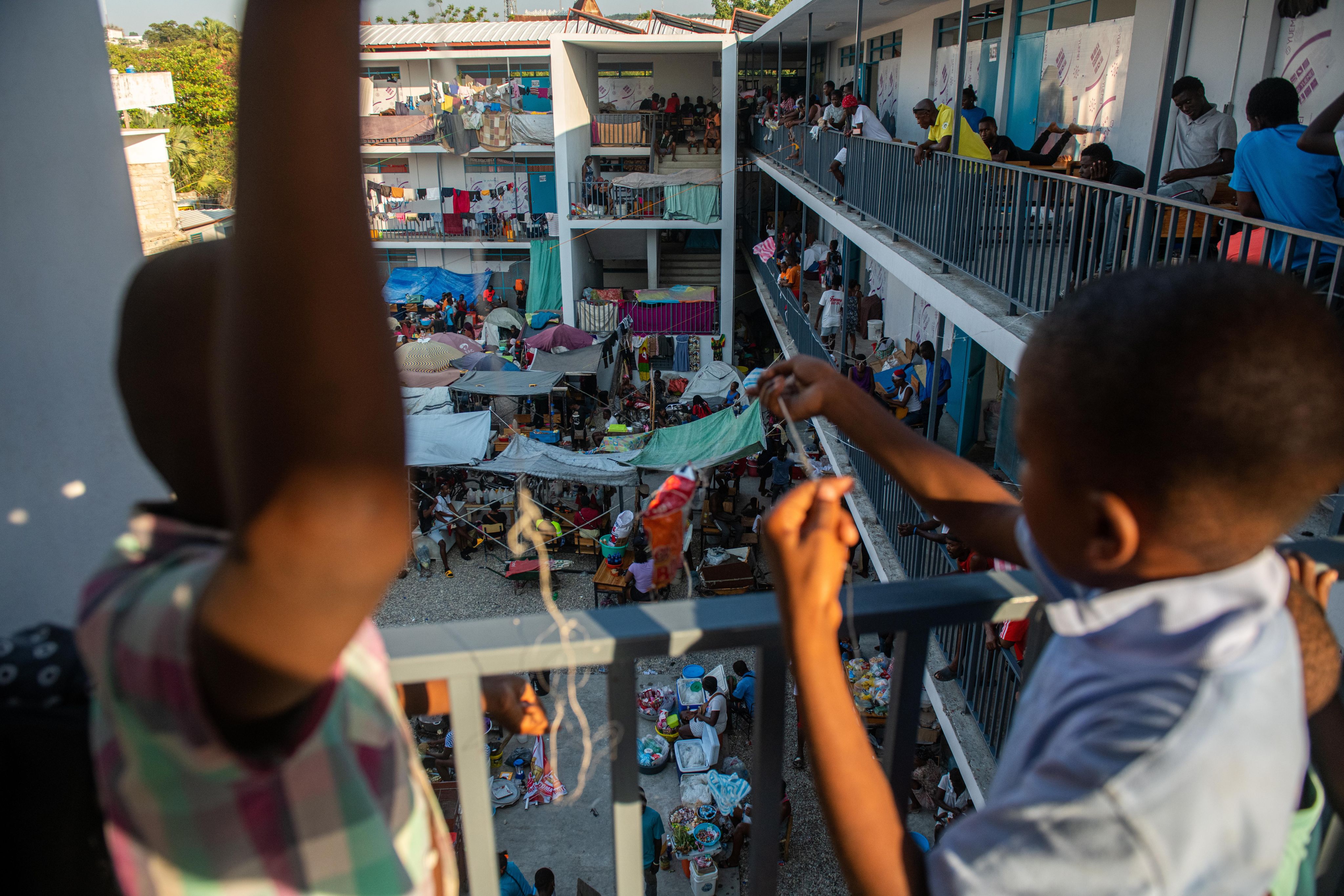 Folk står på balkongene i en tre etasjers skole hvor de har søkt tilflukt i Puerto Principe, Haiti.