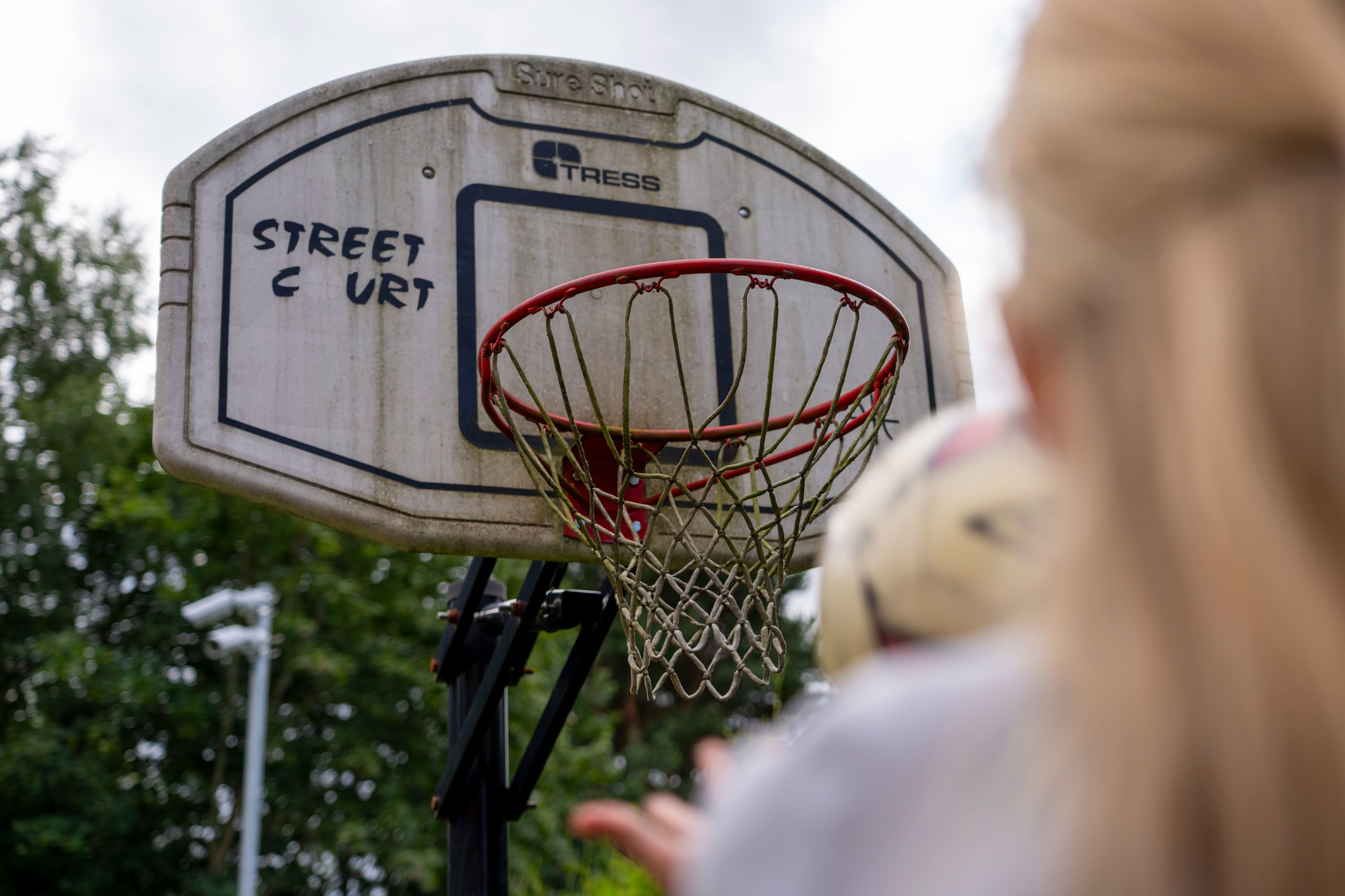 Ei jente er i ferd med å kaste ball i en basketkurv. 
