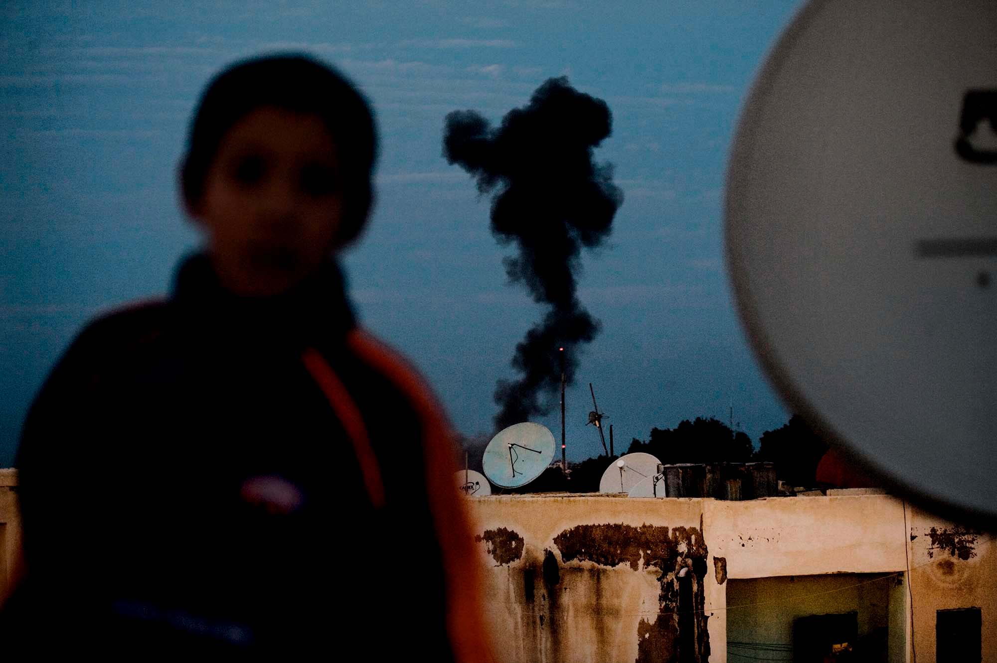 smoke billows from a factory in a city