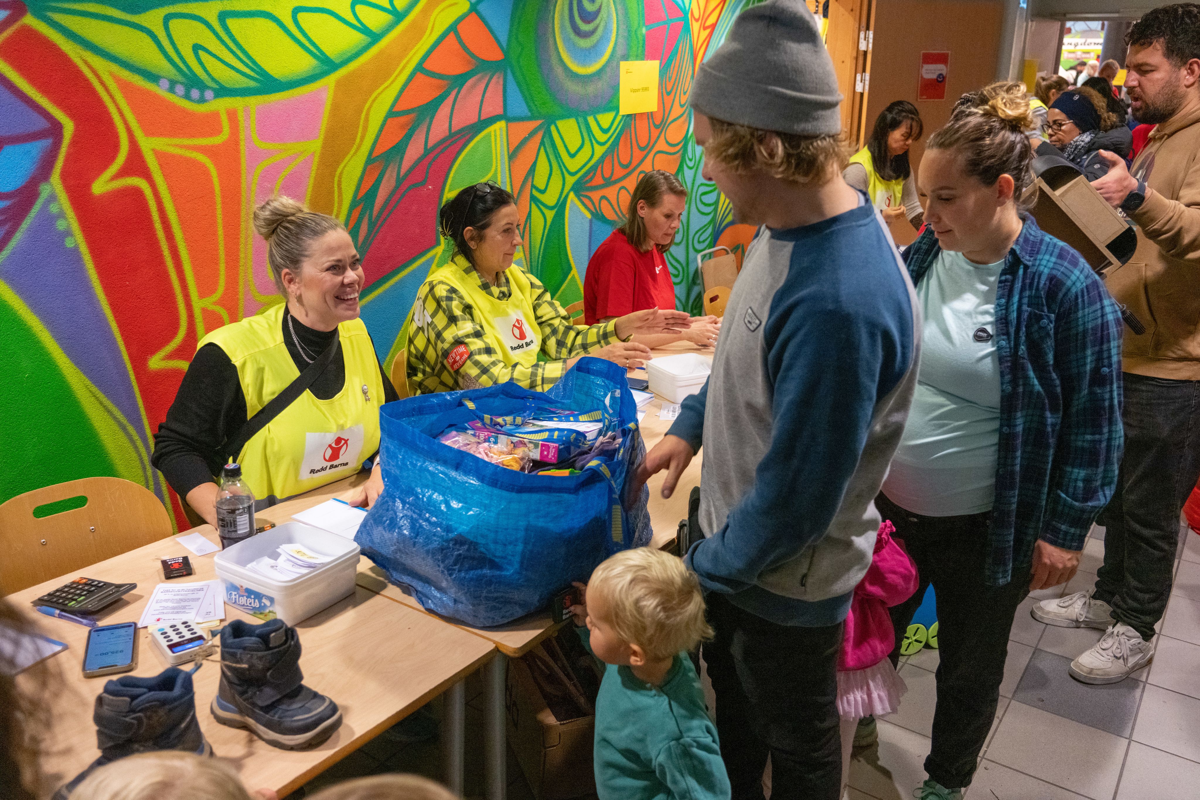 Redd Barna frivillige sitter bak kassebordet og tar i mot kundene. 