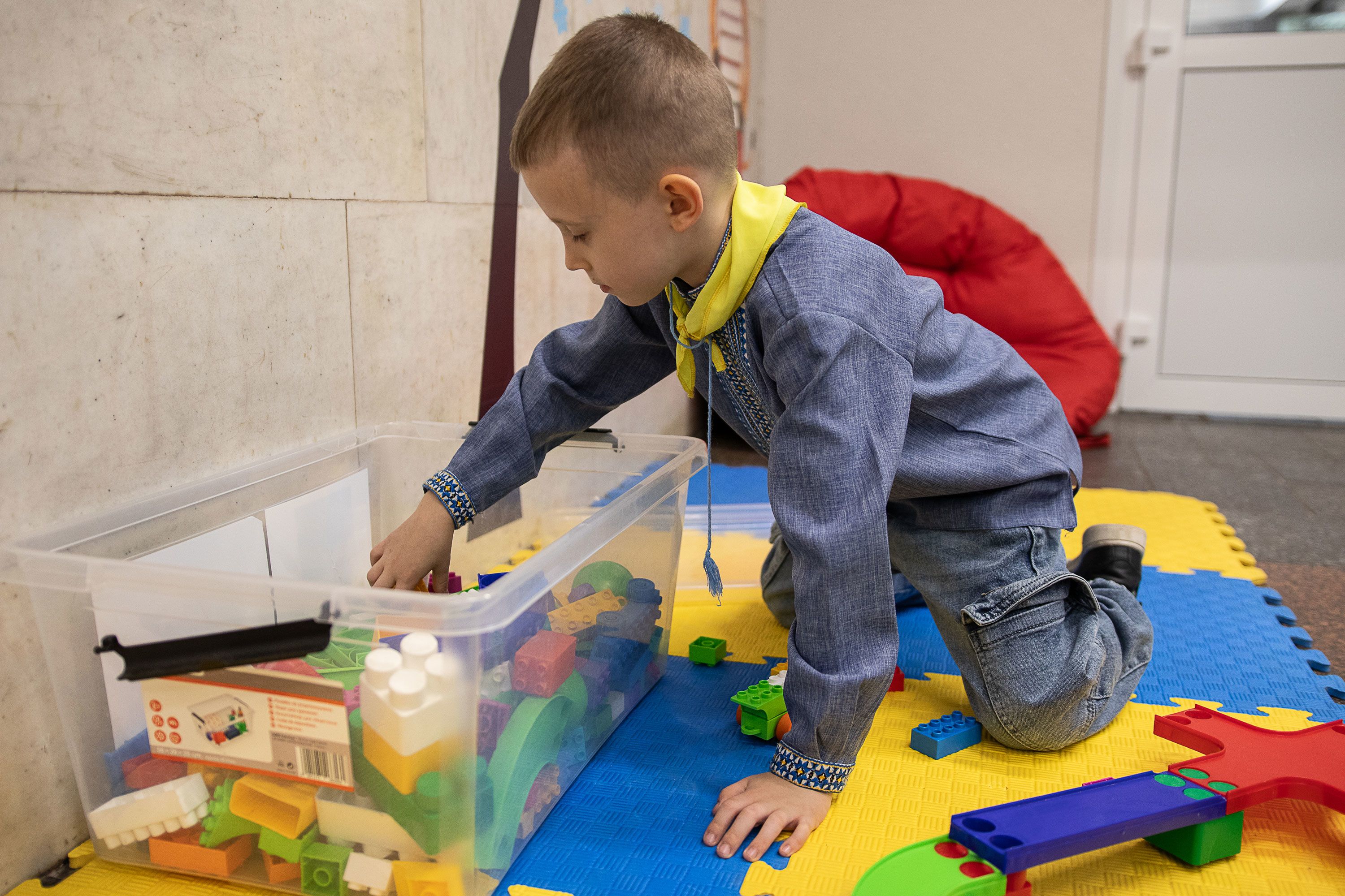 Artem sitter på en lekematte og leker med Duplo.
